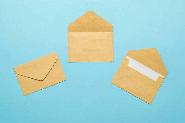 Three postal envelopes on a light blue background. The concept of mail correspondence. Flat lay. - 写真・画像