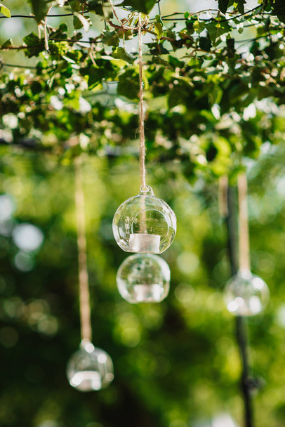 A closeup shot of hanging glass balls with candles for decoration - Fotó, kép