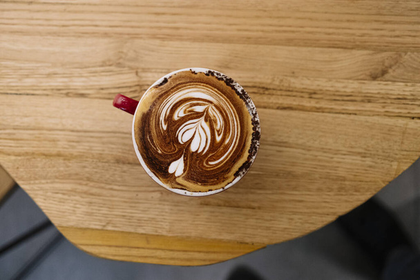 A top view of a tasty cappuccino on a wooden table - Foto, Imagem