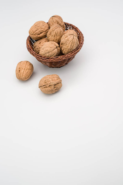 Wicker basket with Stack Walnuts isolated on a white background with free space - Foto, immagini