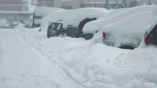 Ένας άντρας καθαρίζει το αμάξι του από το χιόνι. Εκκαθάριση του χώρου στάθμευσης για χιόνι από το χιόνι με ένα φτυάρι. - Πλάνα, βίντεο