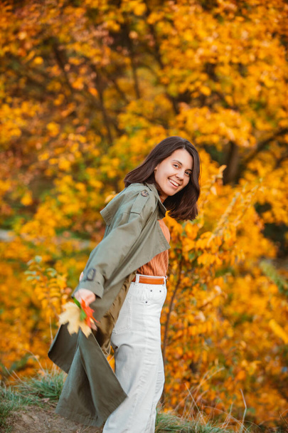 黄金の秋の葉の前の美しい笑顔の女性 - 写真・画像