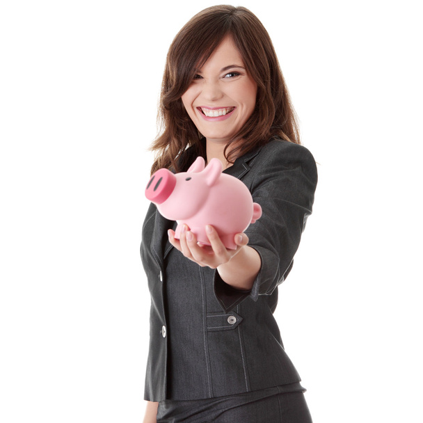 Young beautiful woman standing with piggy bank - 写真・画像