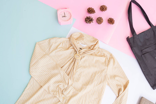 Basic lay-out van dameskleding, shirt op bleke mint pastel achtergrond. Lifestyle concept. wekker. tasje. a) - Foto, afbeelding