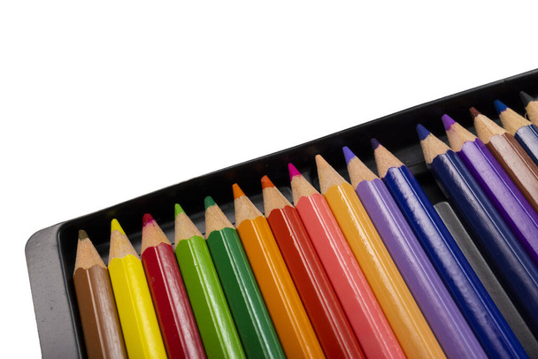 Un vassoio di matite colorate con un colore mancante dal vassoio, isolato su sfondo bianco. - Foto, immagini