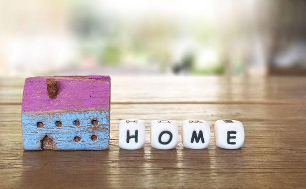 Закрыто красочный небольшой окрашенный деревянный дом модели с небольшими кубиками алфавита написания домой.  - Фото, изображение