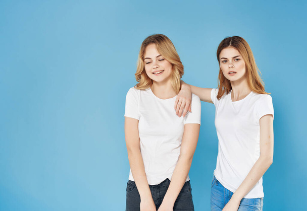 Beyaz tişörtlü iki kadın dostluk iletişimi mavi arka plan - Fotoğraf, Görsel