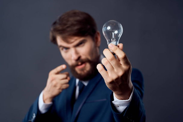 üzletember öltönyben egy lámpával a kezében kreativitás - Fotó, kép