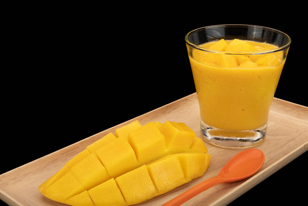 Kalter Mango-Smoothie mit Mangowürfeln im Cocktailglas. - Foto, Bild
