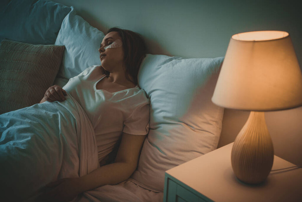 életstílus pillanatok egy fiatal nő otthon. Egy nő alszik az ágyában. - Fotó, kép