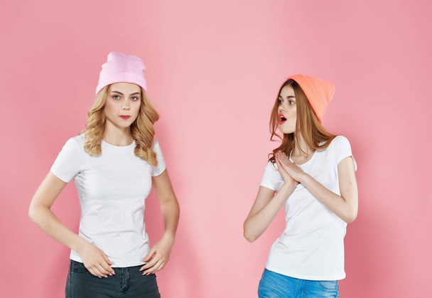 dwie kobiety stoją obok siebie młodzież styl zabawy przyjaźń różowy tło - Zdjęcie, obraz