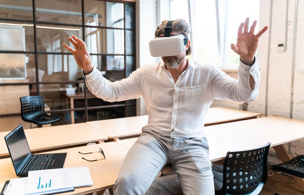 senior business man sitting in his office and using mixed reality to develop a new project - Foto, Imagem