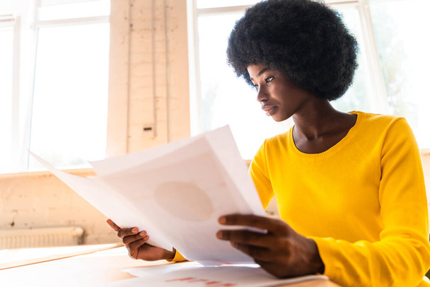 beautiful young woman with the afro haircut working in the office - Foto, afbeelding