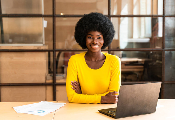 gyönyörű fiatal nő afro frizurával dolgozik az irodában - Fotó, kép