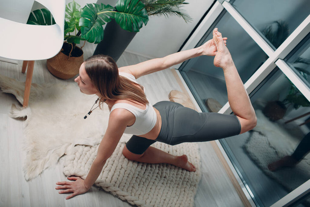 Adult mature woman doing yoga at home living room - Photo, Image