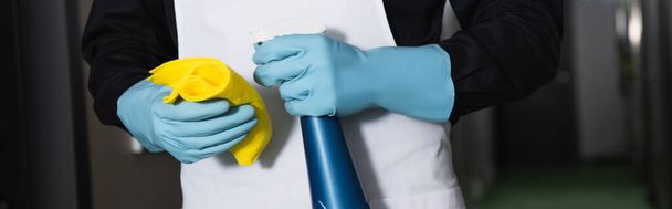 Lastik eldivenli temizlikçinin elinde bez, pankartlı sprey şişeyle kısmi görüntüsü - Fotoğraf, Görsel
