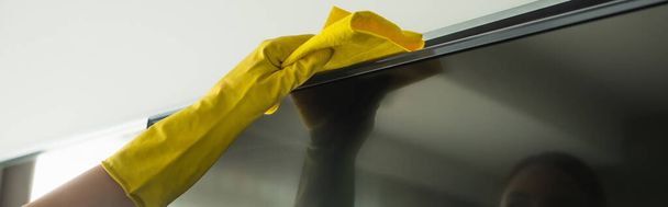 oříznutý pohled hospodyně v gumové rukavici čištění TV displej s hadrem, banner   - Fotografie, Obrázek