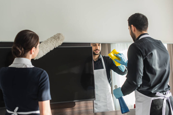 Haushälterinnen putzen im Hotelzimmer mit Putzmitteln - Foto, Bild