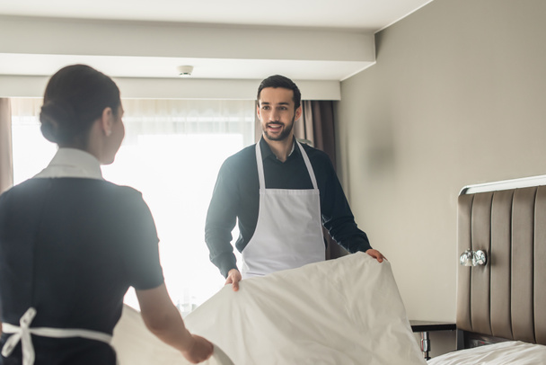 glückliche Haushälterinnen wechseln Bettwäsche im Hotelzimmer  - Foto, Bild