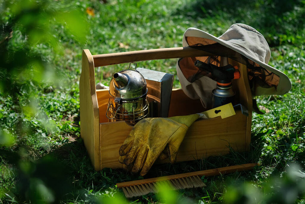 Uma ferramenta do apicultor. Tudo para um apicultor trabalhar com abelhas. Fumador, cinzel, caixa, fato de apicultor para protecção contra as abelhas. Equipamento de apicultura. Foto sobre o tema da apicultura - Foto, Imagem