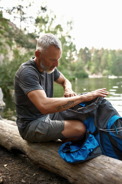 Middle aged caucasian man with tourist backpack resting - Valokuva, kuva