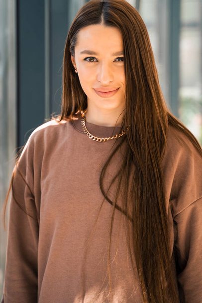 Portrait of a confident girl in a brown sweater - Fotoğraf, Görsel