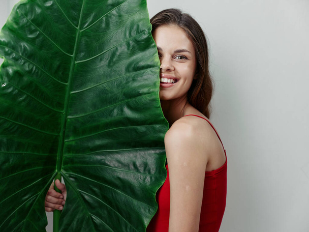 Kırmızı mayo giymiş bir kadın, tropiklerde çekici, hafif arka planda. - Fotoğraf, Görsel