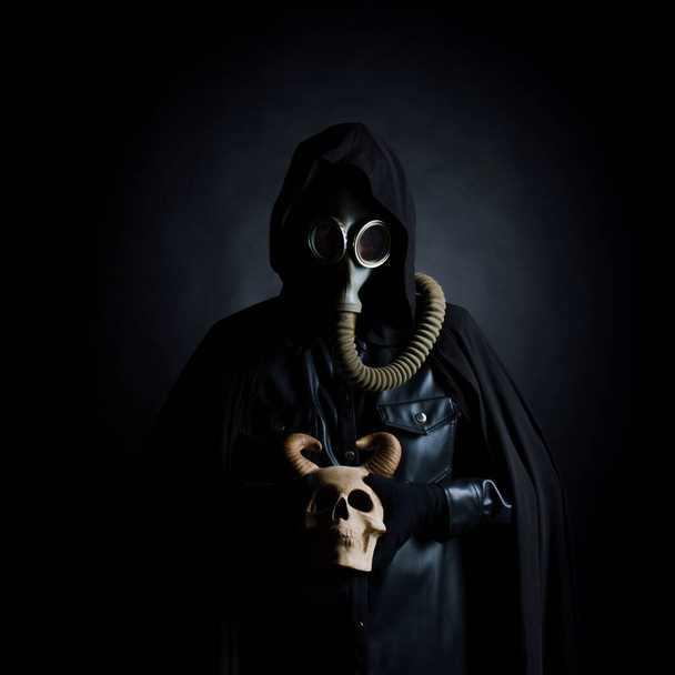 Post-apocalyptic world, concept. A gloomy servant of the devil cult in a black hood - Photo, image