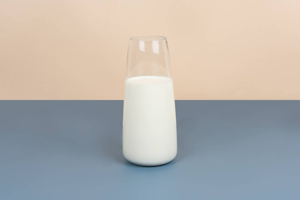 Bílé mléko a mléčné výrobky jsou umístěny na žluté a šedé pozadí - Fotografie, Obrázek