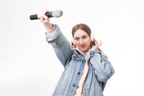 Jonge blanke vrouw met koptelefoon met microfoon geïsoleerd op witte achtergrond. Ik heb een stem. - Foto, afbeelding