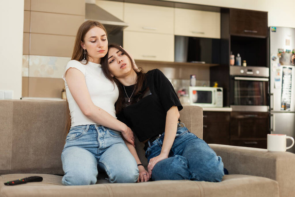 Girl comforting her best friend while sitting on the couch - Foto, Bild