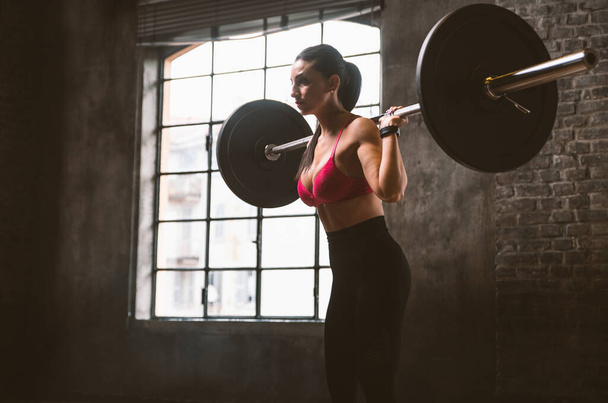 Beautiful woman training and making functional workout in the gym - 写真・画像