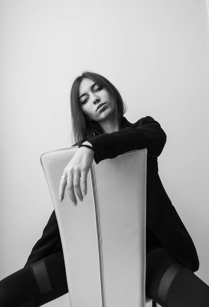 Vogue модна жінка сидить спираючись на стілець
. - Фото, зображення