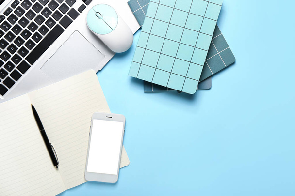 Samenstelling met notebooks, pen, laptop, mobiele telefoon en PC muis op kleur achtergrond - Foto, afbeelding
