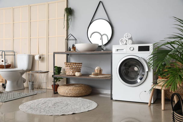 Интерьер ванной комнаты с современной стиральной машиной - Фото, изображение