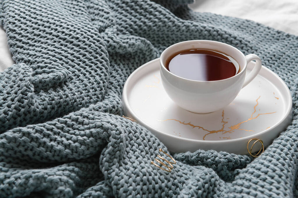 Egy csésze tea gyűrűkkel kötött kockás hajra - Fotó, kép