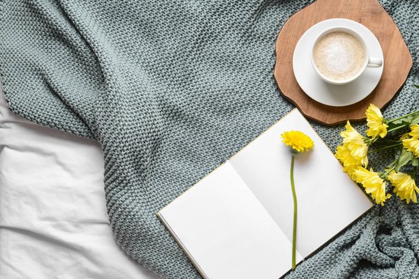 Šálek kávy s knihou a květinami na pletených kostkách - Fotografie, Obrázek