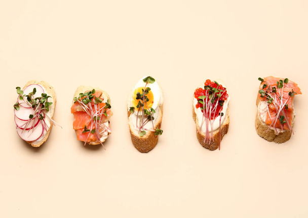 Different bruschettas with micro green on color background - 写真・画像