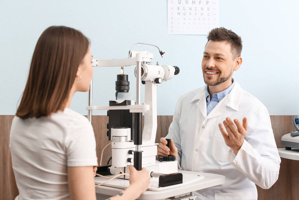 Ophthalmologist examining young woman in clinic - Foto, Bild