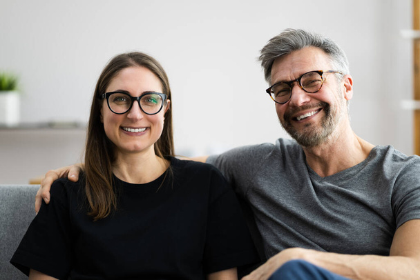 Happy Couple Family On Sofa Or Couch Wearing Eye Glasses - Foto, Bild