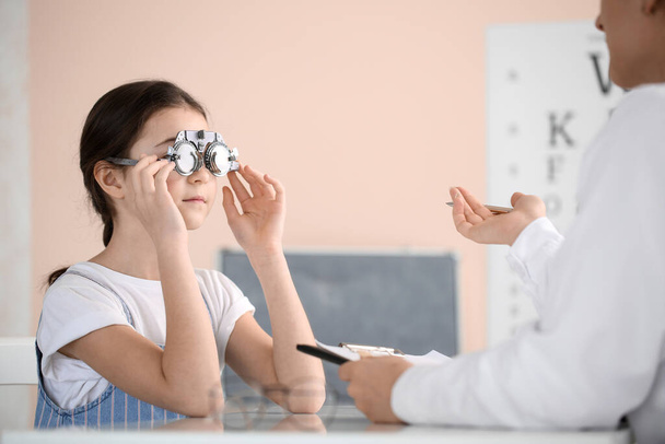 Little girl undergoing eye test in clinic - Fotoğraf, Görsel