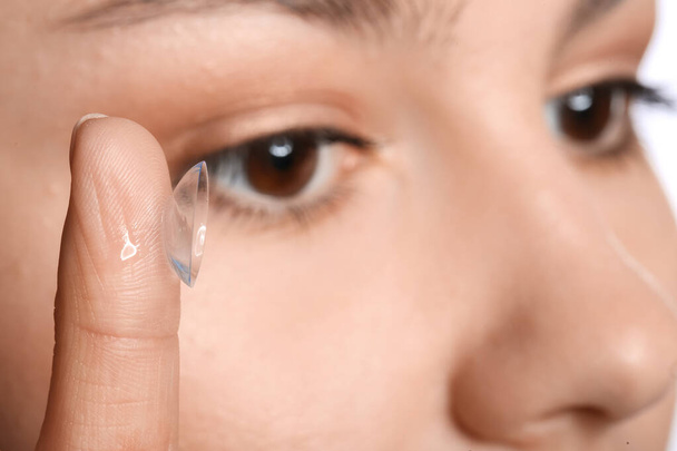 Молода жінка кладе контактні лінзи, крупним планом
 - Фото, зображення