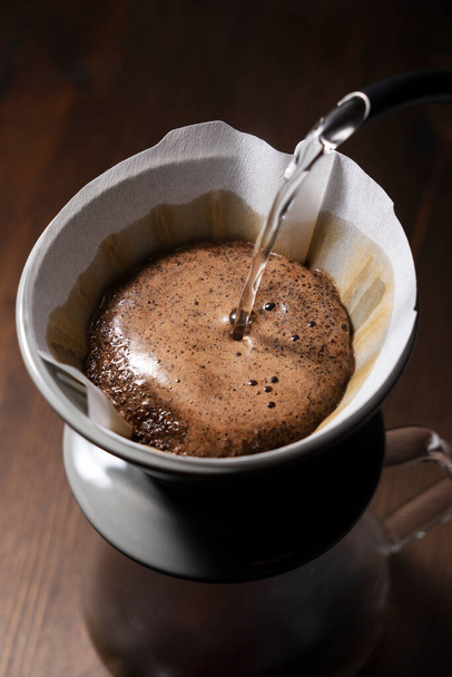 コーヒー粉の上にお湯を注ぐ..ドリップコーヒーを作る. - 写真・画像