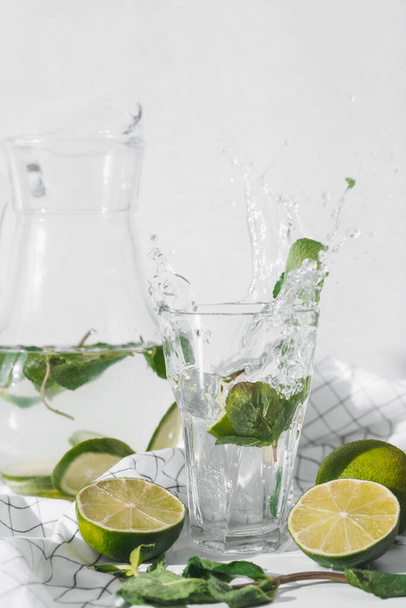 Detox water with lime fruit and mint leaves. Mint fresh homemade lemonade. - Foto, Imagen