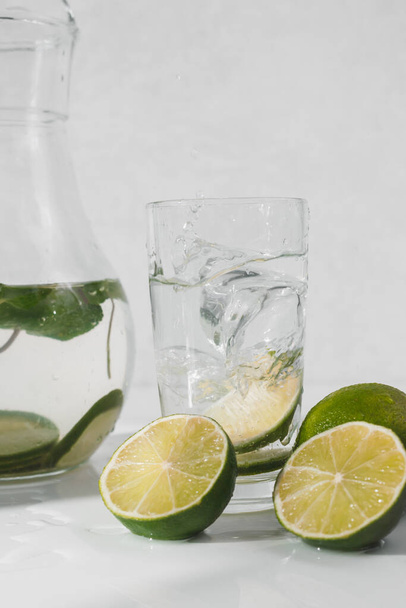 Detox water with lime fruit and mint leaves. Mint fresh homemade lemonade. - Fotó, kép