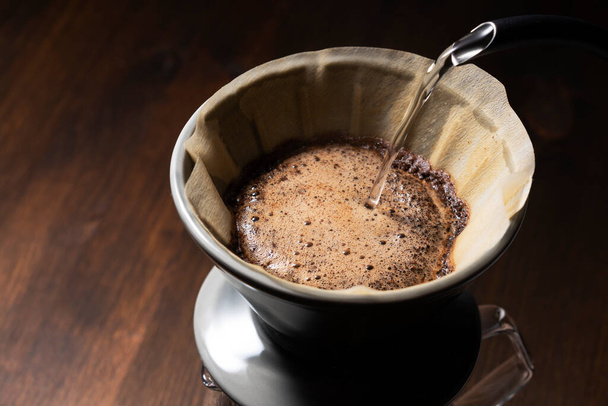 コーヒー粉の上にお湯を注ぐ..ドリップコーヒーを作る. - 写真・画像