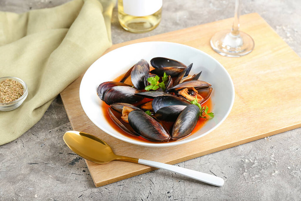 Plate with tasty Mussels Marinara on grunge background - Valokuva, kuva