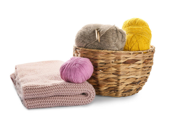 Wicker basket with knitting yarn and plaid on white background - Foto, Imagen