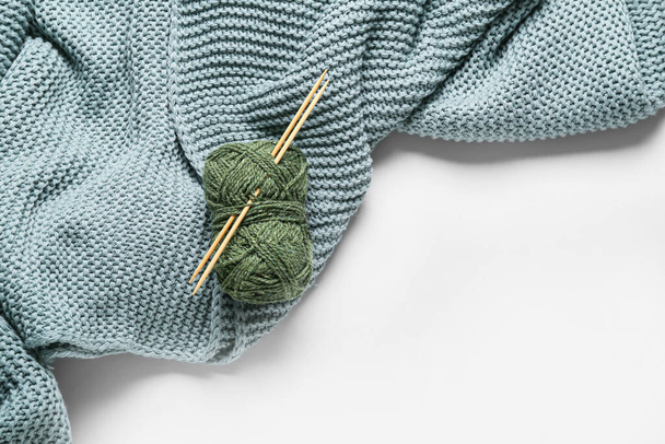 Yarn with knitting needles and plaid on white background - Foto, afbeelding