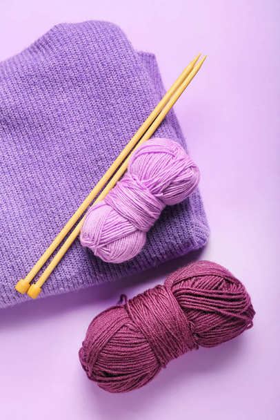 Yarn with knitting needles and plaid on color background - Zdjęcie, obraz